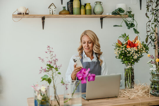 Florist woman using smartphone at flower shop