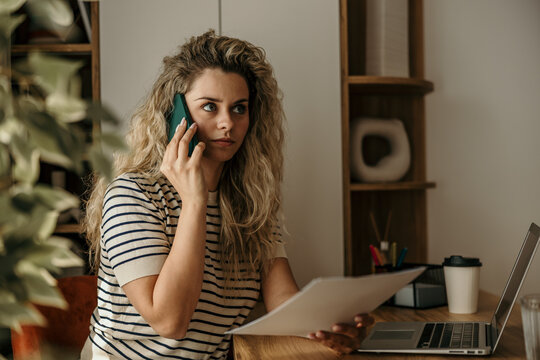 Young woman working remotely having phone call