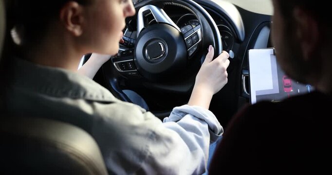 Woman having driving lesson with instructor in car, closeup