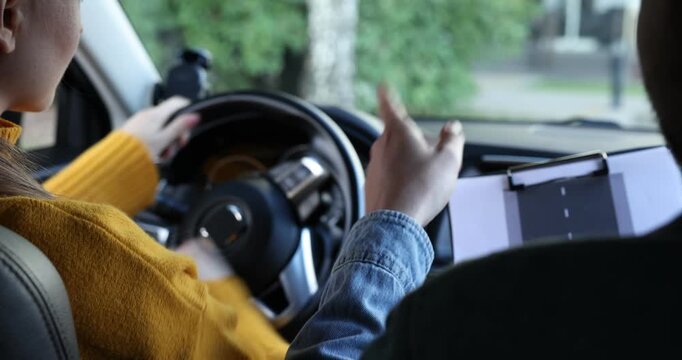 Woman having driving lesson with instructor in car, closeup