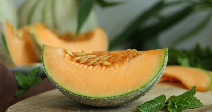 Woman taking piece of Cantaloupe melon from wooden table, closeup