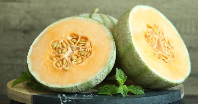 Fresh ripe Cantaloupe melons and mint on table, closeup