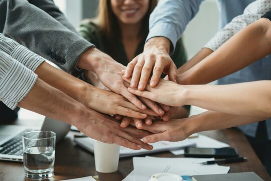 Group of business people stacking their hands together in the office