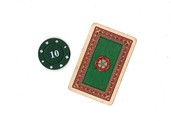 A vintage playing card and poker chip isolated on a white background. © Philip
