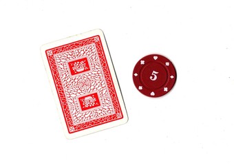A vintage playing card and poker chip isolated on a white background. © Philip