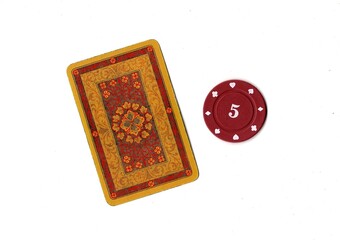 A vintage playing card and poker chip isolated on a white background. © Philip