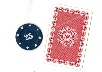 A vintage playing card and poker chip isolated on a white background. © Philip