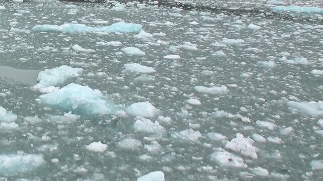 Dense brash ice and floating ice cover the surface of cold water. Additional visible detail includes wide framing, with natural light defining the surrounding forms.
