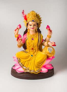 Close up of a beautiful Laxmi idol against white background. Beautifuly crafted statue of Goddess lakshmi which is worshipped on the occasion of most importatnt Hindu festival - Diwali