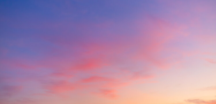 Vibrant Sunset Sky Panorama with Colorful Orange Pink and Blue Clouds,A panoramic photograph capturing a vibrant sunset sky filled with wispy cirrus clouds illuminated in golden yellow, orange, pink, 