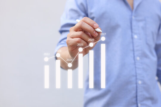 close up manager businessman write and think strategy of business profit with virtual statistic graph for new year 2027 target and financial forecasting in office room concept