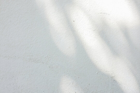 close up on white plain wall background texture with shadow of window from sunlight for ads and advertisement product such as cosmetic or content or goods design display concept