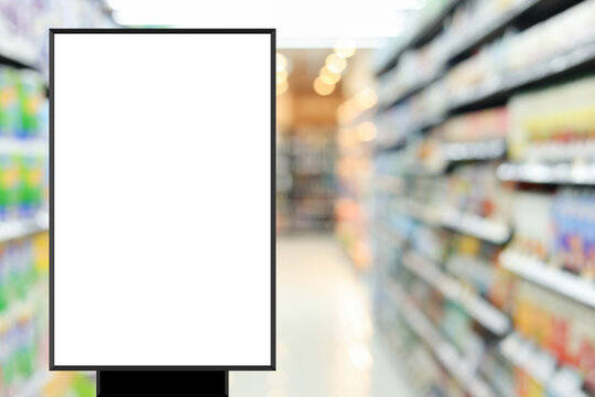 modern blank mockup poster (for ads commercial) standing over blur inside of megastore of local supermarket background in the weekend for billboard design and shopping grocery business concept