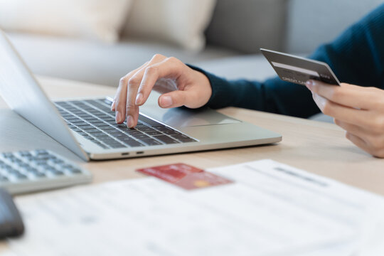 Internet banking, Online shopping at home, asian young woman hand in typing on keyboard, holding credit card, using laptop computer, spending money with purchase on store at home. Shopaholic ecommerce