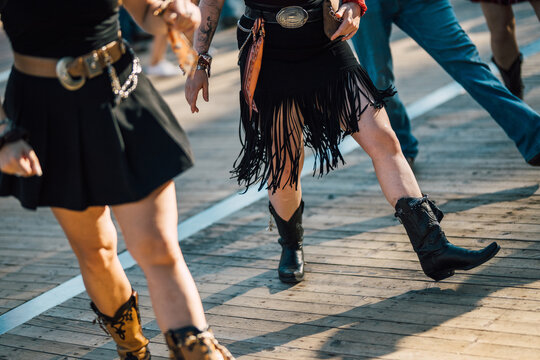 Women in Fringe Skirts Line Dancing Together on Boardwalk