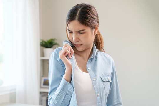 Smelly clothes laundry, housewife woman having bad smelling clothes on the hand holding breath nose with finger, sniff smelly dirty stinky musty and look disgusting.