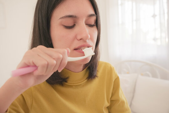 Woman brushing teeth in the morning with natural light, practicing good oral hygiene and healthy lifestyle at home, daily dental care and self-care routine.