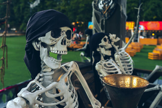 Creepy pirate skeleton prop with black bandana and other ghosts for Halloween outdoor decoration. Ideal concept for outdoor Halloween props, pirate theme party decorations, haunted park attractions,