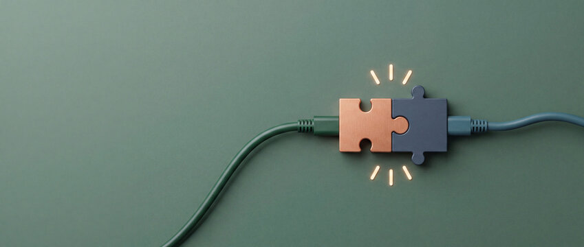 Conceptual image of two jigsaw puzzle pieces joined with electric power cables symbolizing technology integration, digital networking, and innovative business solution on a green background.