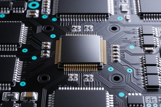 A close-up view of a complex black printed circuit board featuring a central processor and microchips.
