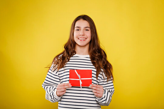 Teen girl holding red gift celebrating joy