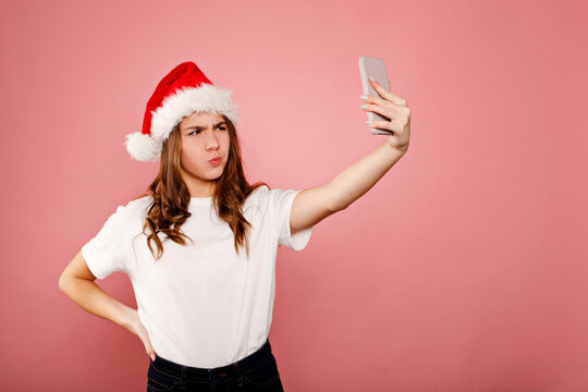 Young girl wearing santa hat taking selfie