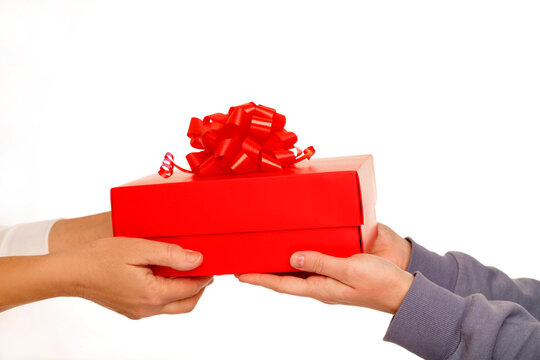Hands exchanging a red gift box with a bow