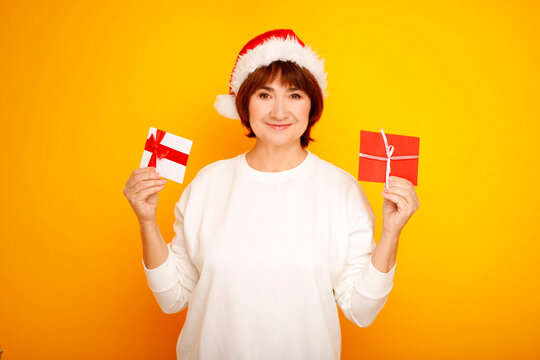 Woman wearing santa hat holding christmas gift cards
