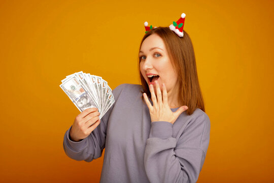 Woman celebrating christmas holding hundred dollar bills