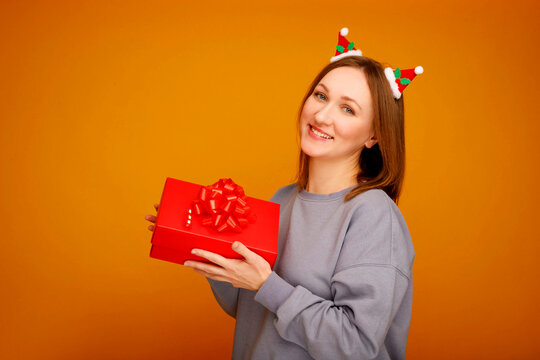 Woman celebrating christmas holding a red gift box