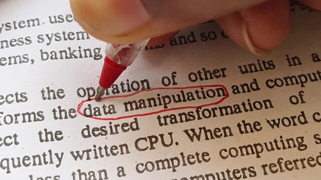 Closeup of hand with red ink pen mark circle around to emphasize or highlight data manipulation word on newspaper article.