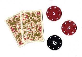 A hand of vintage playing cards and poker chips isolated on a white background. © Philip