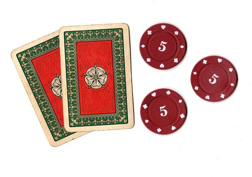 A hand of vintage playing cards and poker chips isolated on a white background.
