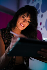 Close up portrait of smiling Caucasian female student using stylus pen on digital tablet under ambient light, completing online education course assignments e-learning notes and research © BullRun