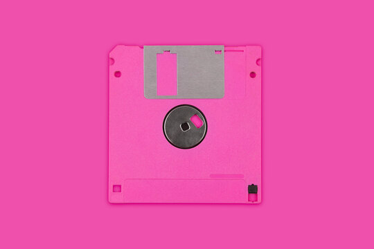 Pink vintage 3.5 inch floppy disk isolated on a matching pink back