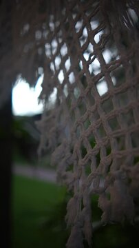 Textura de rede artesanal balan&ccedil;ando suavemente, com vista desfocada de c&eacute;u azul e mar ao fundo, transmitindo relaxamento, paz e tranquilidade em um lugar tropical paradis&iacute;aco durante dia de viagem 