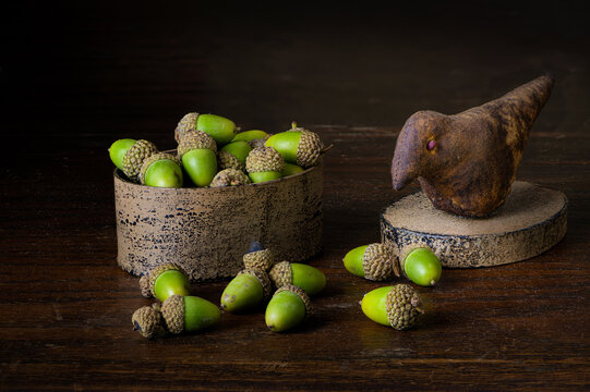 Still life with acorns and box with bird sculpture on lid.
