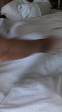 M&atilde;o feminina relaxando entre len&ccedil;&oacute;is brancos macios em manh&atilde; aconchegante de viagem, sensa&ccedil;&atilde;o de conforto e descanso em quarto de hotel