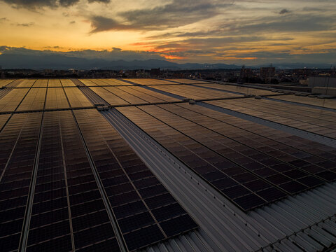 Aerial view of solar panel array on a rooftop at sunset in the Zama industrial area in Zama, Kanagawa, Japan.