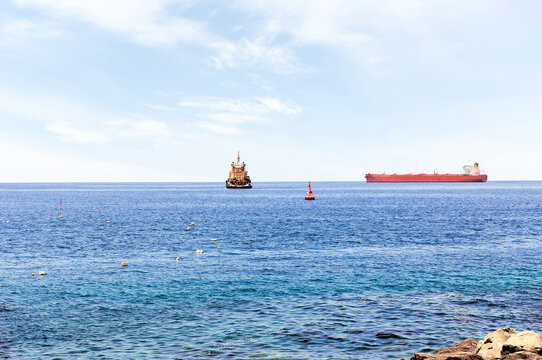 Large sea tanker for transporting oil floats into the sea. Rendezvous of two ships on the high seas. Strait of Hormuz. Tanker ship on the horizon