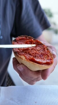 Close up of hand spreading traditional sobrasada on toast for breakfast, Spanish cuisine, Mallorcan food, Mediterranean lifestyle, authentic local gastronomy, traditional food culture