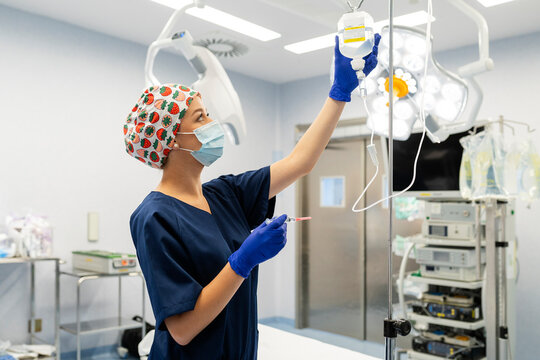 Nurse preparing iv drip in operating room