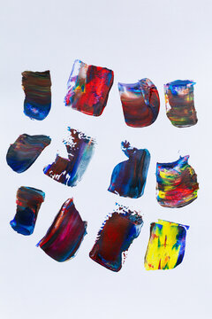 Strokes of multi-colored paint on the surface of paper