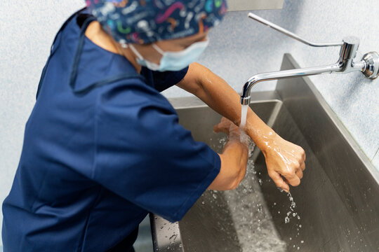 Surgeon washing hands for surgical scrub in hospital