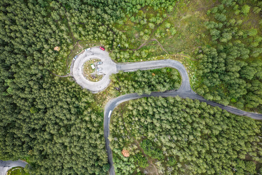 Aerial view of Alpine Loop Scenic Byway inn autumn featuring a winding road loop surrounded by dense aspen, juniper, and evergreen forest in Utah County, Utah, United States.