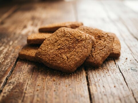 Biscuits stacked on a rustic wooden table create a cozy and simple composition.