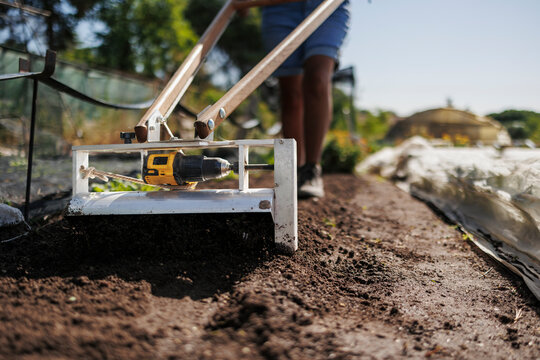 Gardener using innovative planting tool preparing fresh soil
