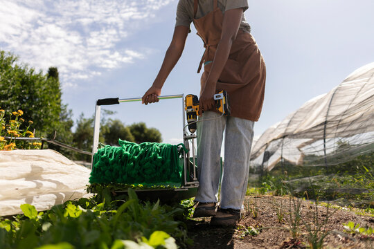 Person using electric farm tool cultivating organic vegetables