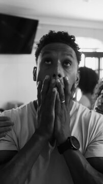 African American father rubbing face in exhaustion while overwhelmed by teenage children