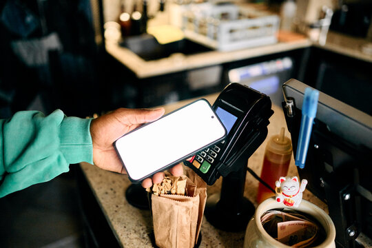 Customer Paying with Smartphone via NFC Terminal at Cafe Counter